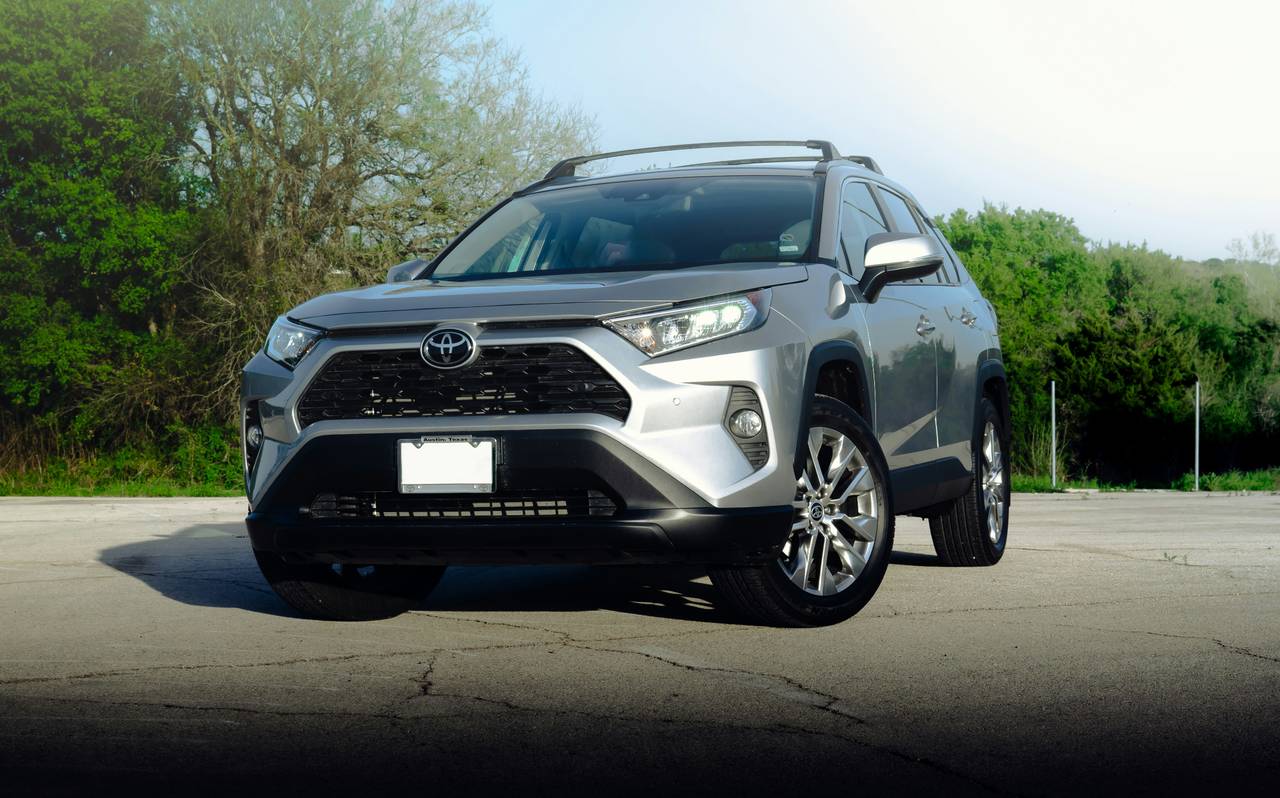Silberner Toyota RAV4, schräg von vorne, auf einem leeren Parkplatz