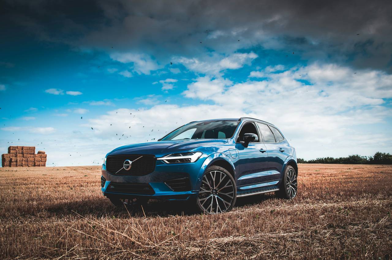 Blauer Volvo XC60, schräg von vorne, auf einem abgeernteten Feld